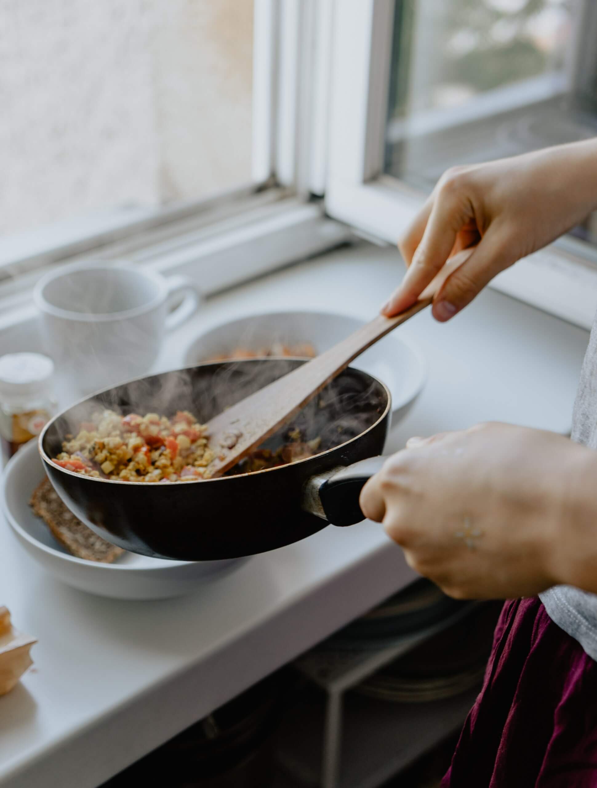 Person cooking and pouring into a bowl