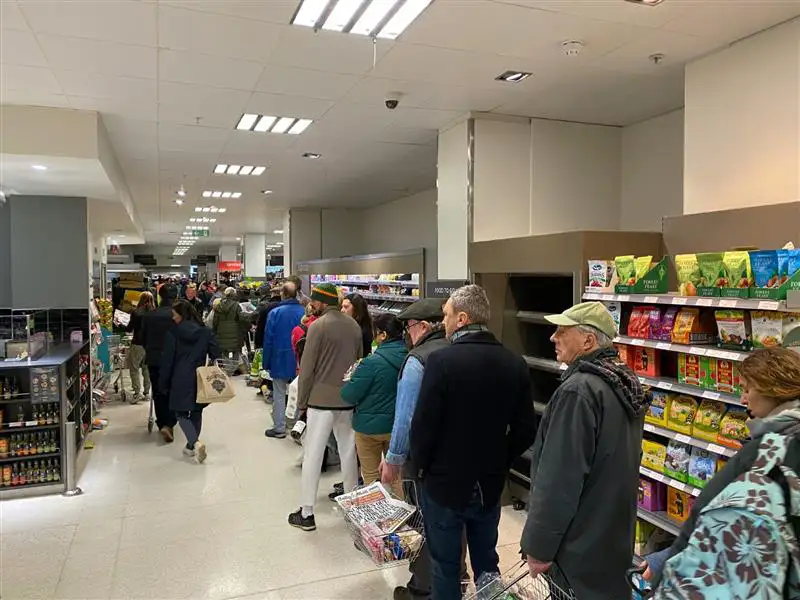 A line of people waiting to pay at a British grocery store.